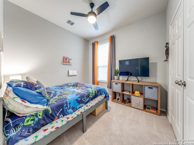 carpeted bedroom with a ceiling fan, visible vents, a closet, and baseboards