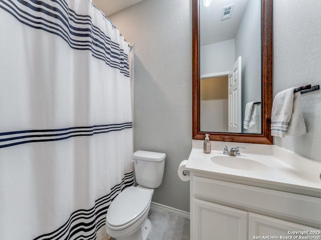 bathroom featuring vanity, toilet, a textured wall, and visible vents