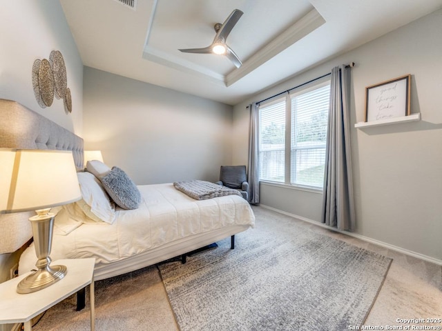 bedroom with a raised ceiling, carpet, baseboards, and ceiling fan