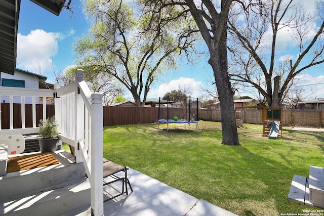 view of yard with a fenced backyard, a playground, and a trampoline