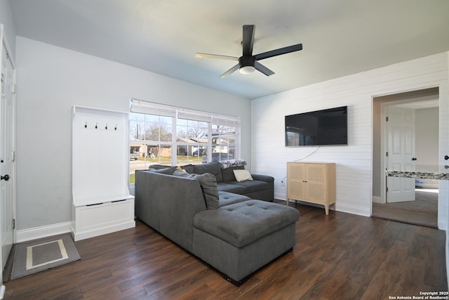 living room featuring dark wood-type flooring, baseboards, and ceiling fan