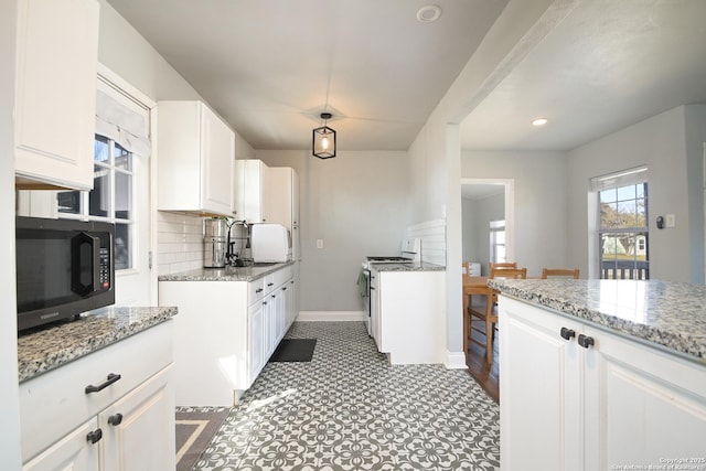 kitchen featuring backsplash, white cabinets, gas range gas stove, and a sink