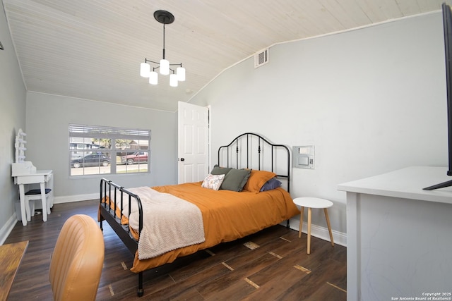 bedroom with an inviting chandelier, vaulted ceiling, wood finished floors, and baseboards