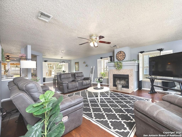 living area featuring visible vents, wood finished floors, and ceiling fan