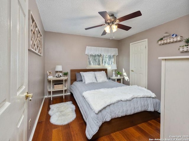 bedroom featuring wood finished floors, baseboards, and a textured ceiling