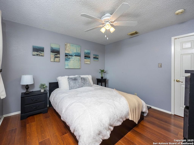 bedroom featuring visible vents, a textured ceiling, and wood finished floors