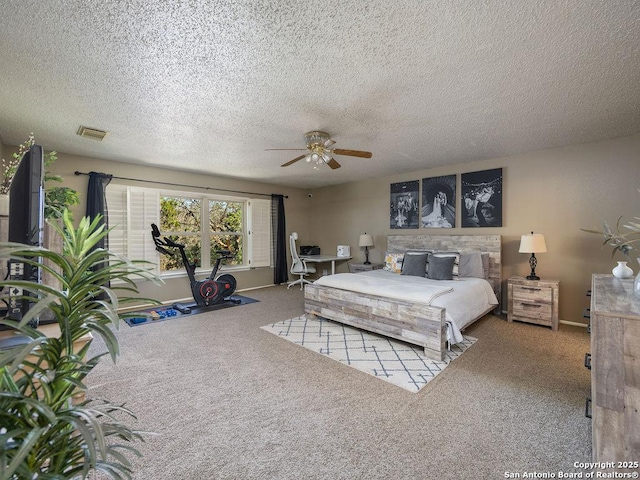 bedroom with visible vents, a textured ceiling, carpet floors, baseboards, and ceiling fan