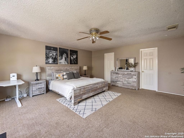 carpeted bedroom featuring visible vents, a textured ceiling, and ceiling fan