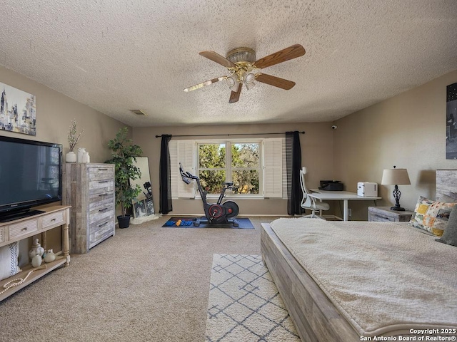 bedroom with a textured ceiling, carpet flooring, visible vents, and ceiling fan