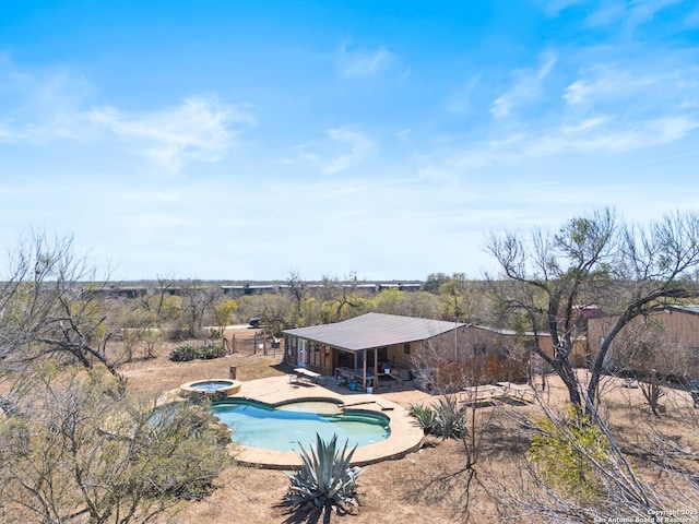 outdoor pool featuring an in ground hot tub and a patio area