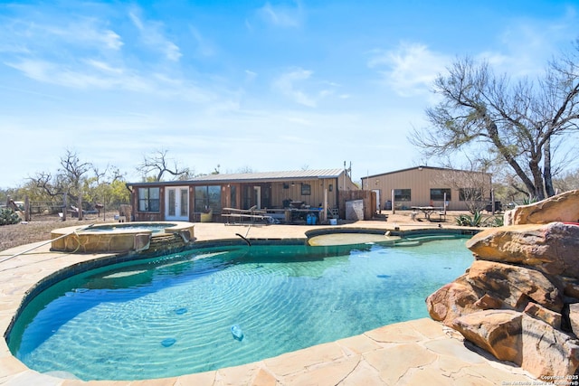 view of swimming pool with a patio, french doors, and a pool with connected hot tub