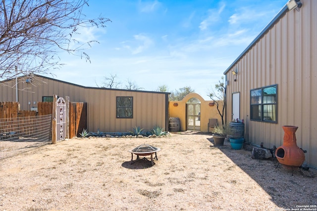 view of yard featuring a gate, an outdoor fire pit, and fence