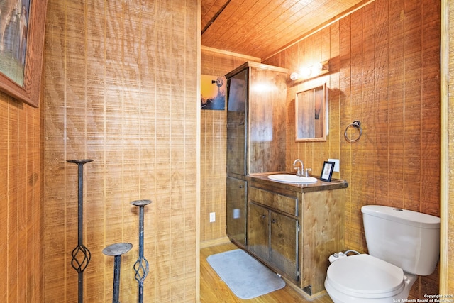 full bathroom featuring toilet, wood finished floors, tiled shower, wood ceiling, and vanity