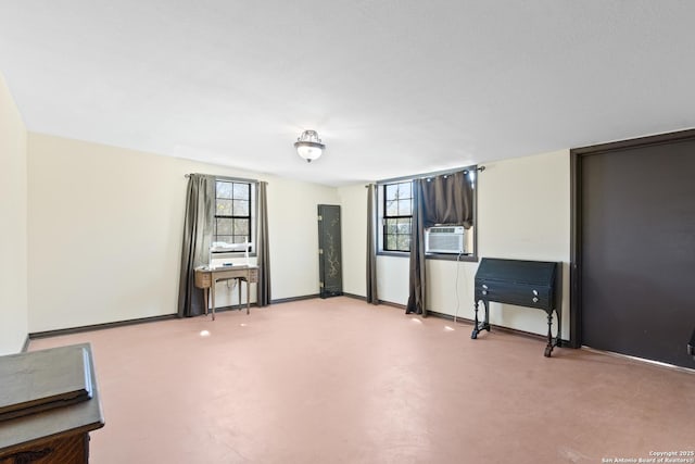 spare room with plenty of natural light, cooling unit, finished concrete flooring, and baseboards