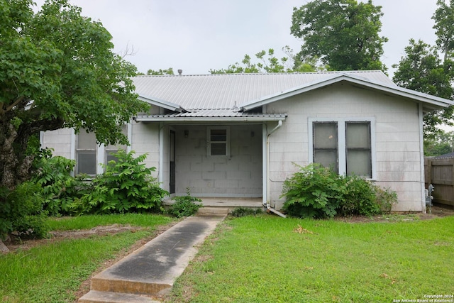 bungalow featuring a front yard and metal roof