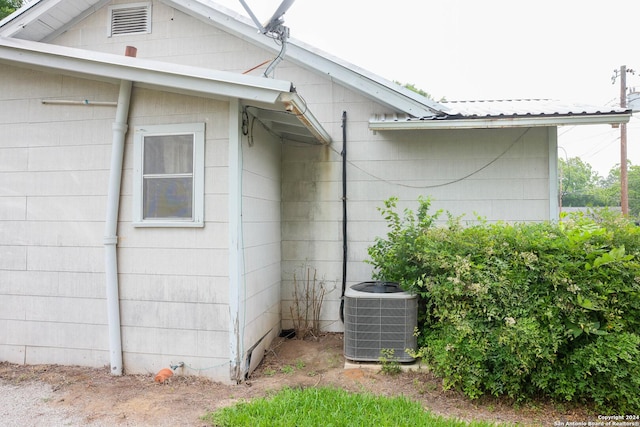 view of property exterior featuring cooling unit and metal roof