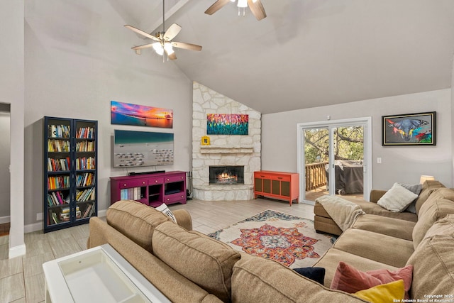 living room featuring a stone fireplace, a ceiling fan, light wood-style floors, and high vaulted ceiling