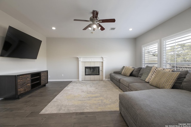 living room featuring visible vents, recessed lighting, a fireplace, baseboards, and dark wood-style flooring