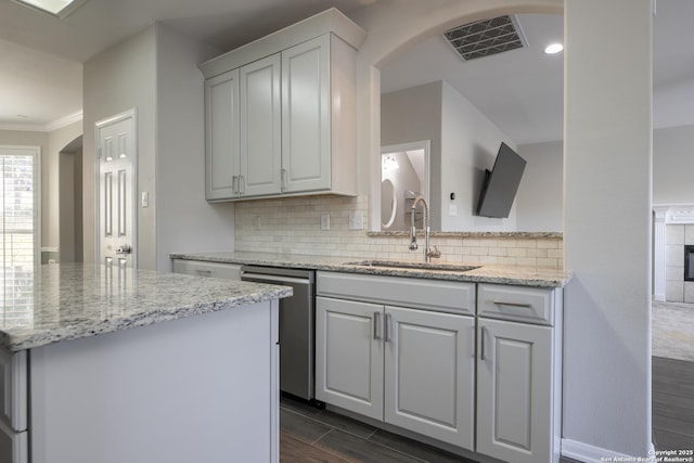 kitchen with wood finish floors, visible vents, a sink, decorative backsplash, and dishwasher