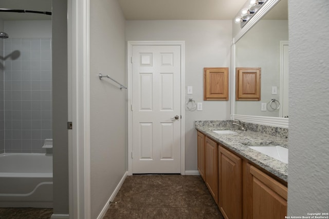 bathroom featuring double vanity, tub / shower combination, baseboards, and a sink