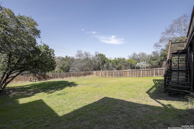 view of yard featuring stairway and a fenced backyard