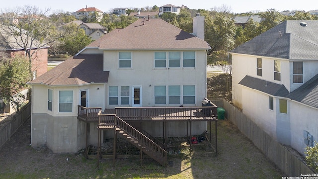 rear view of property featuring a wooden deck, stairway, a chimney, and a fenced backyard