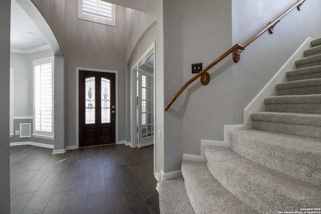 foyer featuring stairway, baseboards, dark wood-style floors, and ornamental molding