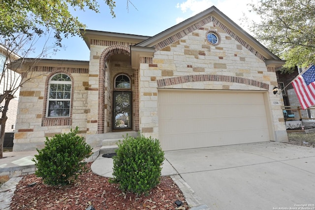 view of front of home featuring a garage, stone siding, brick siding, and concrete driveway