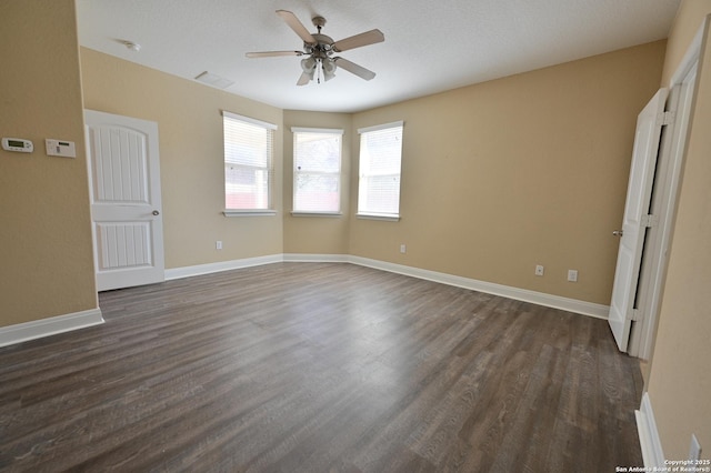 unfurnished bedroom with a ceiling fan, dark wood-type flooring, visible vents, and baseboards