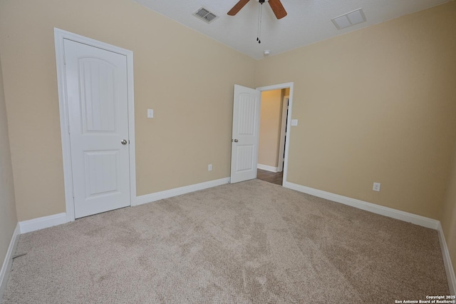 carpeted spare room with baseboards, visible vents, and ceiling fan