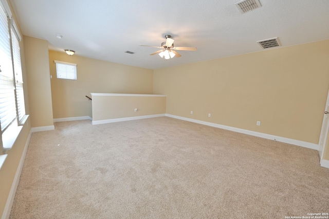 spare room with visible vents, baseboards, and light colored carpet