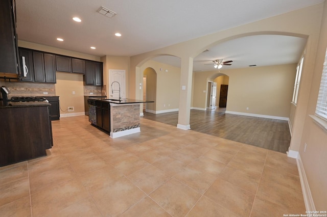 kitchen with visible vents, tasteful backsplash, dark countertops, open floor plan, and white microwave