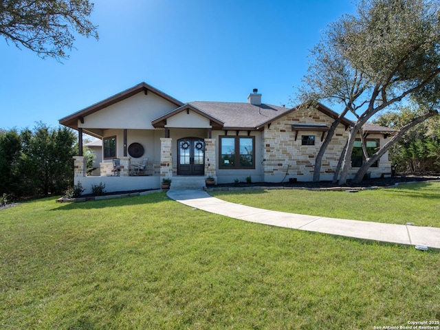 view of front of house featuring stucco siding, a chimney, a front lawn, french doors, and stone siding