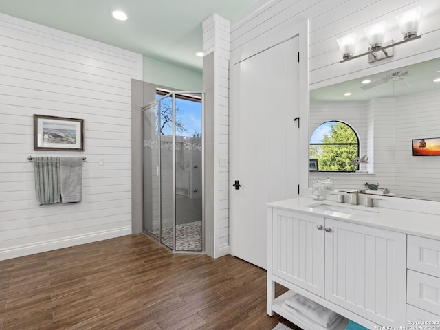 bathroom featuring recessed lighting, a shower stall, vanity, and wood finished floors