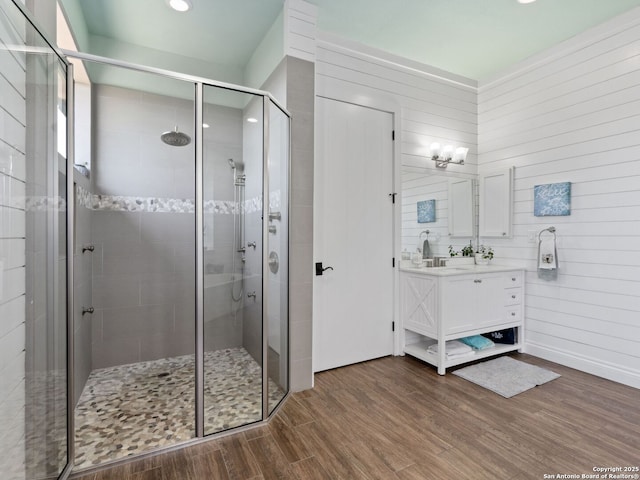 full bathroom featuring a stall shower, vanity, and wood finished floors