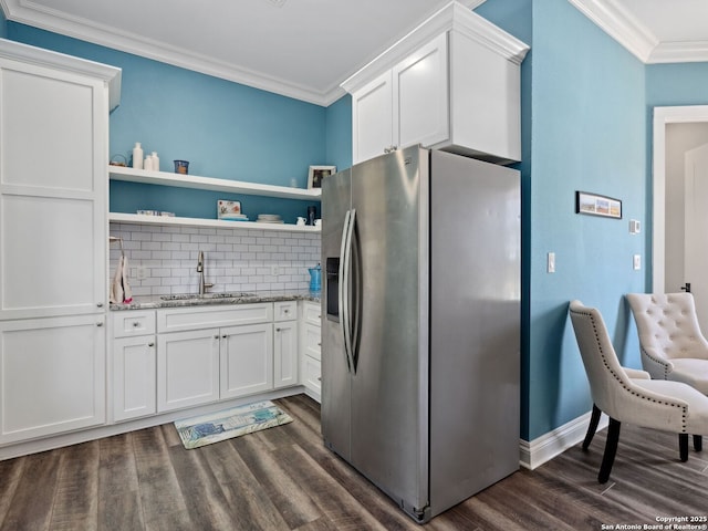 kitchen with stainless steel refrigerator with ice dispenser, a sink, open shelves, white cabinets, and crown molding