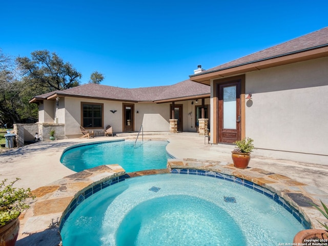 view of swimming pool with a patio area and a pool with connected hot tub