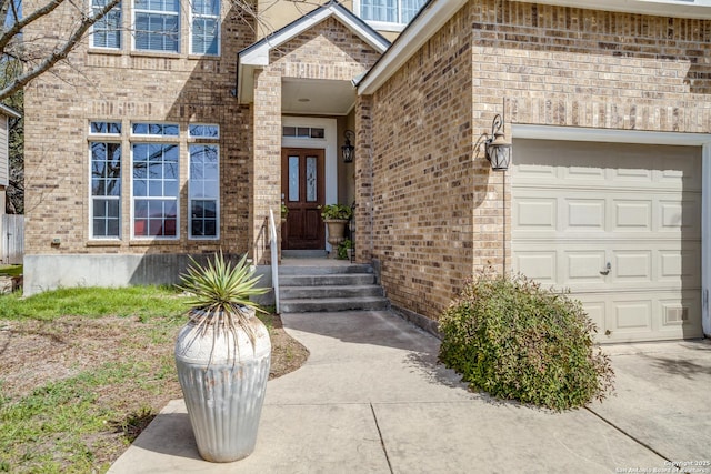 property entrance featuring a garage and brick siding