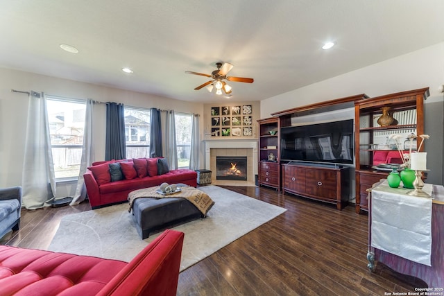 living area with recessed lighting, a tile fireplace, ceiling fan, and wood finished floors