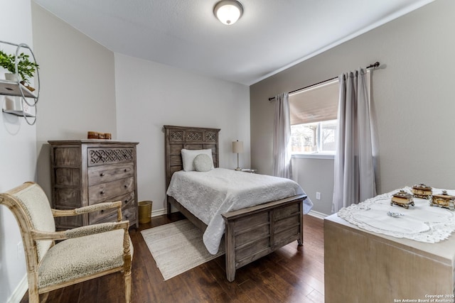 bedroom with baseboards and dark wood-style flooring