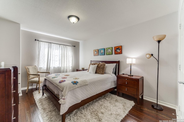 bedroom featuring dark wood finished floors and baseboards