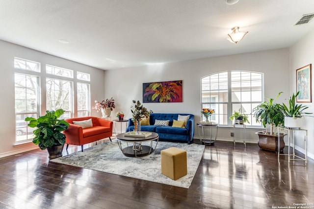 living room featuring wood finished floors, visible vents, and a wealth of natural light