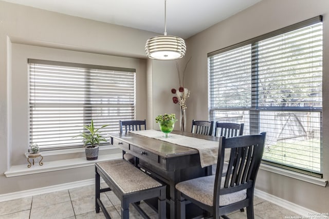 dining room featuring baseboards, plenty of natural light, and light tile patterned flooring