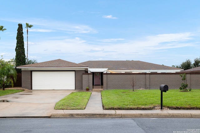 view of front facade with a front yard, fence, driveway, an attached garage, and brick siding