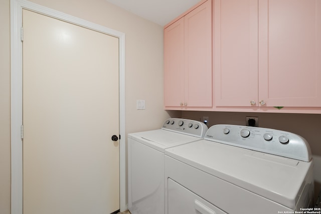 washroom featuring cabinet space and washer and clothes dryer