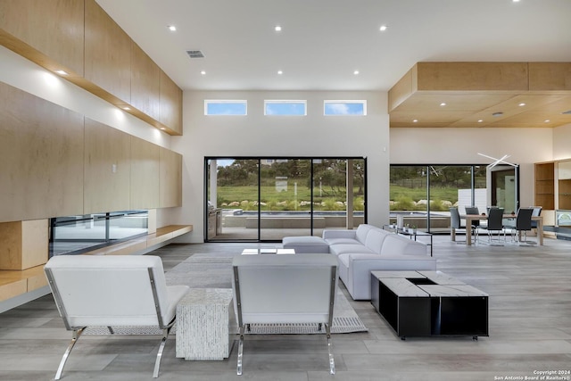 living area featuring visible vents, recessed lighting, and a towering ceiling