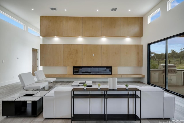 living room with visible vents, recessed lighting, baseboards, and a towering ceiling