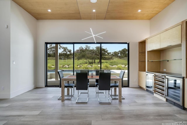 dining room with wine cooler, light wood-style floors, and a healthy amount of sunlight