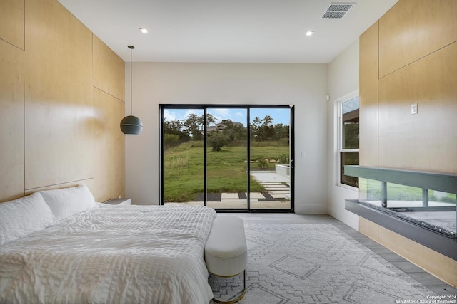 bedroom featuring access to exterior, visible vents, multiple windows, and light wood-style floors