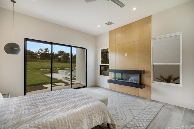 bedroom with baseboards, visible vents, a fireplace, access to exterior, and light wood-type flooring